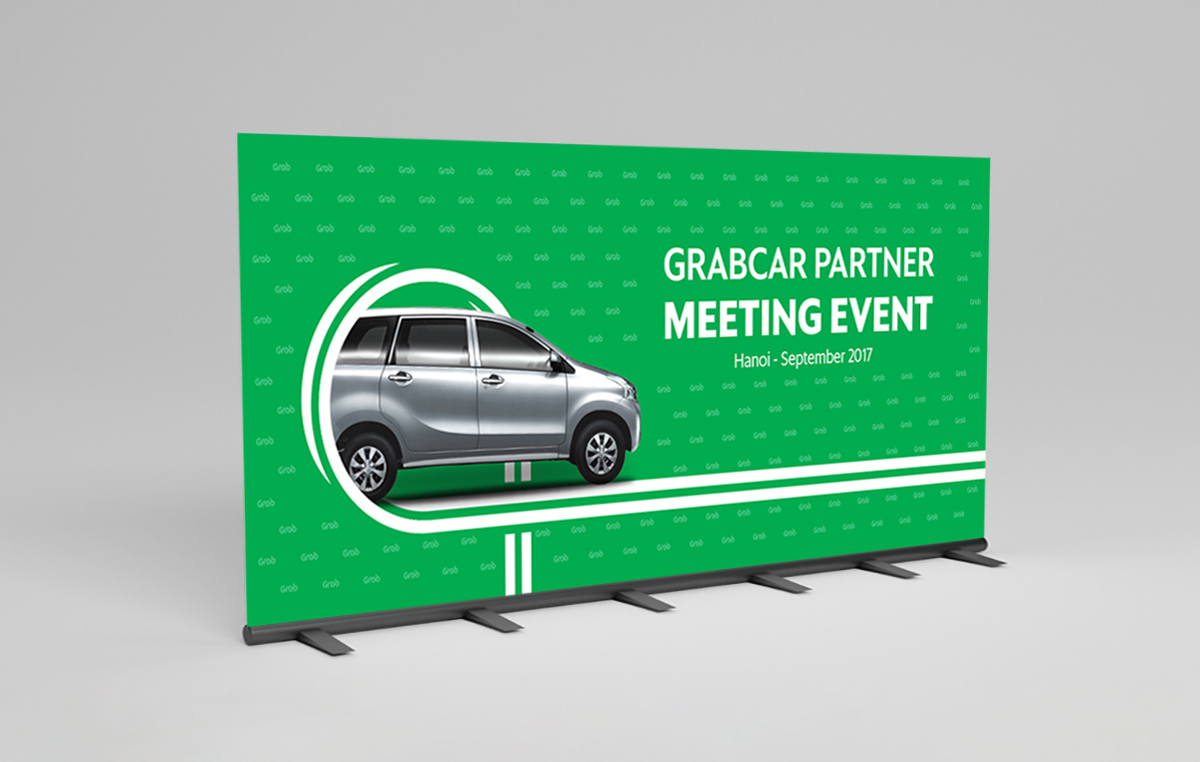 a green backdrop with grab-logo pattern on background and a car driving to the right and the text grabcar partner meeting event